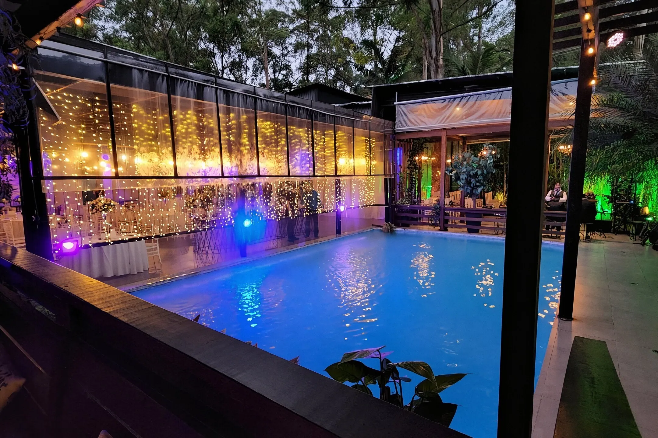 Lounge ao ar livre do Espaço Cedrom com piscina e vegetação
